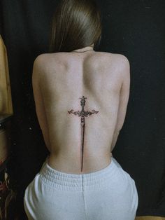 a woman with a cross tattoo on her back and the upper part of her body