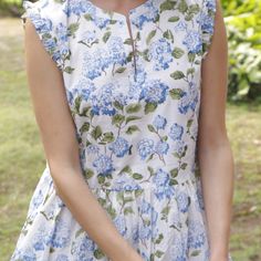 a woman in a blue and white floral dress