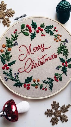 a cross stitch christmas ornament surrounded by other holiday decorations