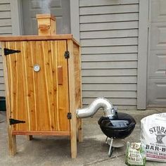 a bbq and smoker sitting on the side of a house