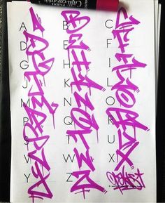 a piece of paper with pink graffiti on it and a marker next to it that says alphabet