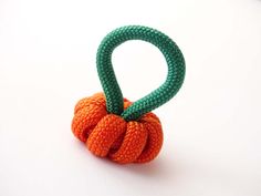 an orange and green knoted object sitting on top of a white table