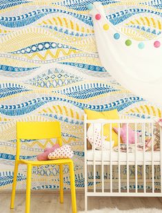 a baby's room with a yellow chair and white crib in the foreground