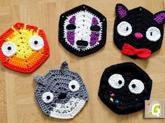 four crocheted animal hats with eyes and nose designs on them sitting on a wooden surface