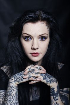 a woman with tattoos on her arms posing for the camera