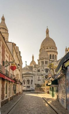 an empty street in front of buildings with domes on the top and bottom half of them