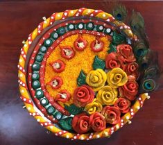 a decorative bowl with flowers and feathers in it