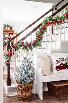 christmas decorations on the banisters and stairs in a living room with white furniture