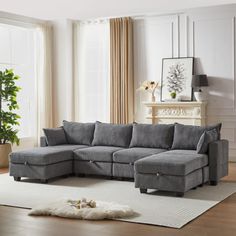 a living room with a gray sectional couch and white rug in front of a fireplace