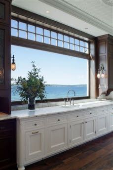 a large kitchen with an island in the middle and lots of windows overlooking the ocean