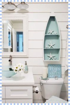 a bathroom with a blue and white decor on the wall, toilet and sink in it