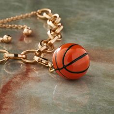 an orange basketball is hanging from a gold chain