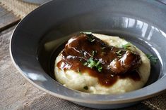 a bowl filled with mashed potatoes covered in gravy