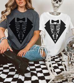 This Skeleton Costume Tee features a stylish twist with a skeleton rib cage design layered beneath the image of a sleek suit. Perfect for those who want to add a spooky, yet classy, flair to their outfit, the shirt displays a detailed rib cage with bones popping out from underneath a sharp suit jacket and tie. Whether you're dressing up for Halloween or just want to showcase your quirky style, this shirt offers a fun and unique way to combine spooky skeleton vibes with formal attire. Ideal for c Rib Cage Shirt, Skeleton Suit, Skeleton Top, Skeleton Rib Cage, Skeleton Tshirt, Cage Thoracique, Shirt Display, Skeleton Costume, Suit Shirt