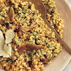 a bowl filled with pasta, mushrooms and parmesan cheese on top of it