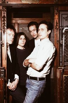 four people standing in front of a wooden door