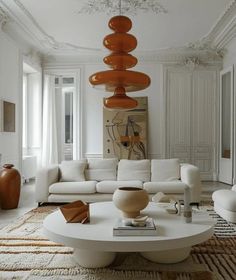 a living room filled with white furniture and large chandelier hanging from the ceiling