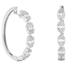 The oval shape cluster in these 18KT White Gold Illusion Hoop Earrings is an artistic masterpiece, showcasing a thoughtful arrangement of natural diamonds. This oval cluster is a crucial part of the illusion setting that is designed to maximize the appearance and sparkle of each diamond. In this design, multiple diamonds are set closely together within the oval-shaped frame, creating an illusion of a larger, single stone. Each diamond in the cluster is placed with precision, to play off one anot Dangler Earrings, Diamond Hoop Earrings, Baguette Diamond, Brilliant Diamond, Jewelry Earrings Hoops, Oval Diamond, San Valentino, Oval Shape, Round Diamond