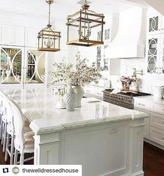 a large kitchen with white cabinets and an island in front of the stove top oven