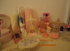 there are many items on the table including candles, perfume bottles, and other things