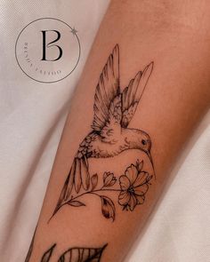 a bird with flowers on it's arm and the letter b is shown in black ink