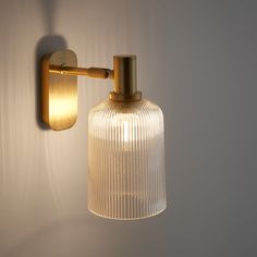 a light that is on the wall next to a white wall and it has a glass shade