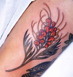 a close up of a person's arm with a tattoo on it and flowers