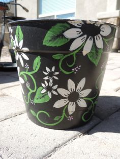 a painted flower pot sitting on top of a sidewalk