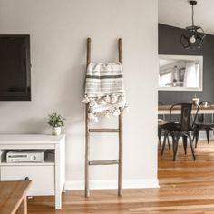 a ladder leaning against the wall with a towel on it in a living room next to a tv