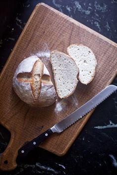 a loaf of bread sitting on top of a cutting board next to a knife