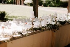 the table is set with candles, flowers and wine glasses for an elegant wedding reception