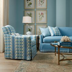 a living room with blue furniture and pictures on the wall