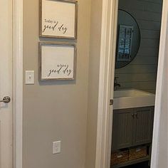 a bathroom door is open to reveal a white sink and mirror with two framed pictures on the wall