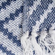 a blue and white blanket with tassels on it