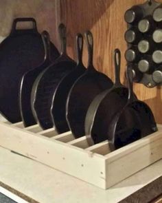 pots and pans are sitting in a wooden holder