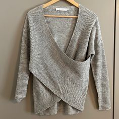 a gray sweater hanging on a hanger