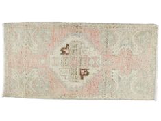 an antique rug with pink and blue colors