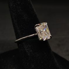 a diamond ring sitting on top of a black cloth