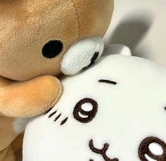 a brown teddy bear hugging a white stuffed animal