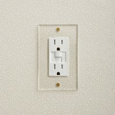 a white light switch sitting on top of a wall next to a beige wallpaper