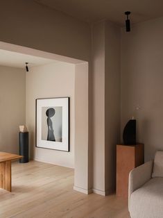 a living room filled with furniture and a painting on the wall next to a coffee table