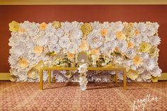 a table with flowers on it in front of a wall