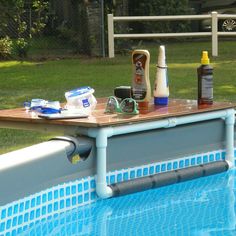 an empty swimming pool with various items on the edge, including sunscreen and deodorant