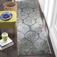 a blue and white rug on the floor next to a yellow chair with a hat on it