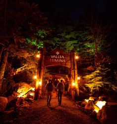 people are walking through the woods at night in front of a sign that says la valalea d'ewina