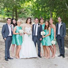 a group of people standing next to each other on a dirt road in front of trees