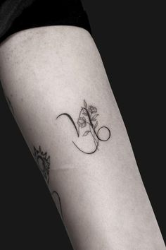 a woman's leg with a flower tattoo on the left side of her arm