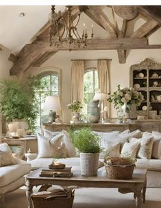 a living room filled with lots of furniture and flowers in vases on the table