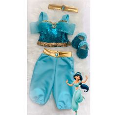 the little mermaid doll is dressed in blue and gold