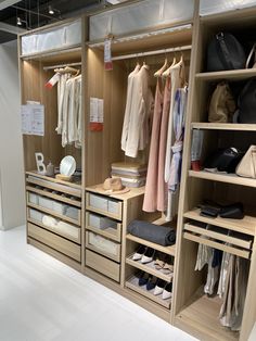 an organized closet with clothes, shoes and handbags on the shelves in front of it